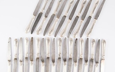 Suite of twenty-nine table knives, the handles in filled silver decorated with roughened flutes ending with a cartouche armoirié flanked by laurel branches linked by a knot, the blades in steel.