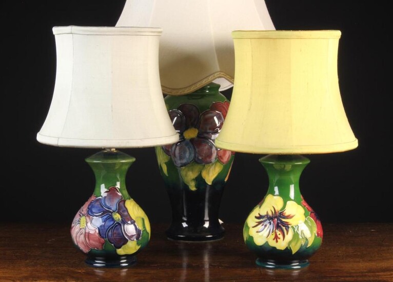 Three 20th Century Moorcroft Lamps: The largest of baluster form decorated with clematis on a dark b