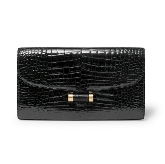 Yves Saint Laurent - a black crocodile Muse clutch bag.