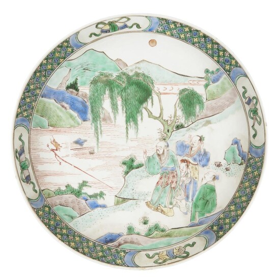 AMENDMENT to condition report as follows: Three hair lines from the rim, of 5.5cm, 3cm, 3cm respectively. Nibbling to the rim and foot rim, wear to the enamels.A Chinese famille verte dish, Kangxi period, painted with a sage throwing a dragon head...