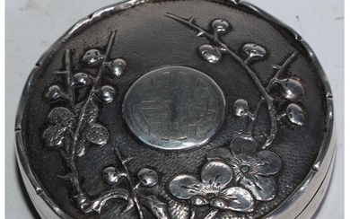 A Chinese silver circular box, hinged cover chased with blos...