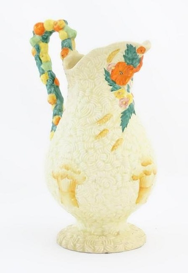 A Clarice Cliff harvest jug decorated with moulded fruit handle, the baluster body decorated with