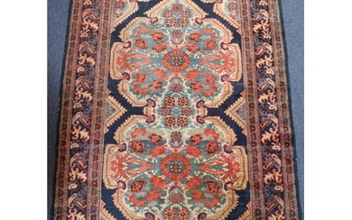 A Persian rug on red and blue ground with 2 centre medallion...