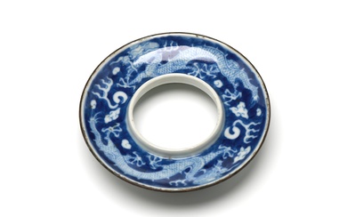 A blue and white porcelain saucer painted with dragons writhing amidst clouds on a blue ground