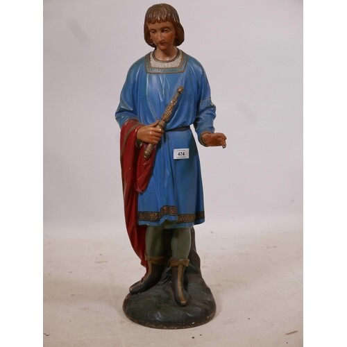 A carved and painted wood figure of a young man in medieval ...
