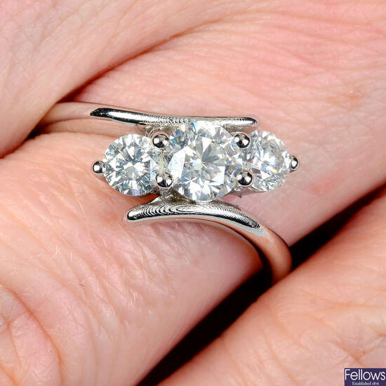 A graduated brilliant-cut diamond three-stone ring, with asymmetric sides.