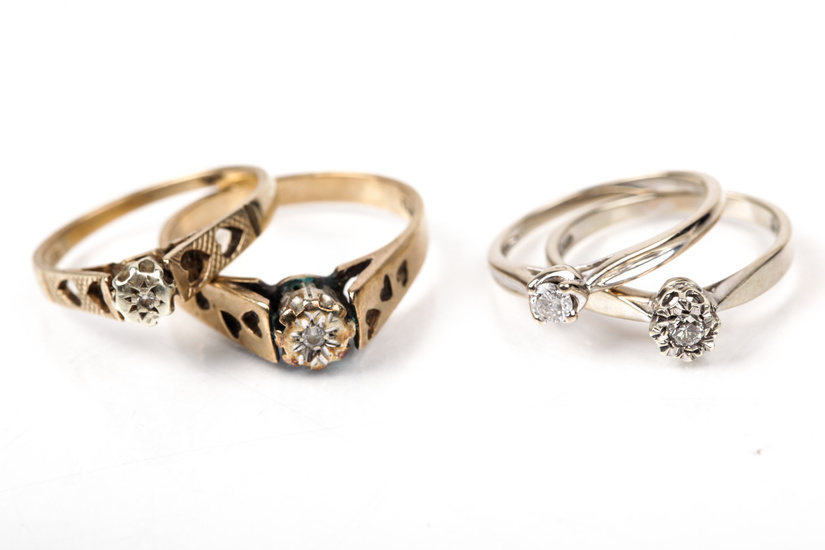 A group of four 9ct gold and diamond solitaire rings.