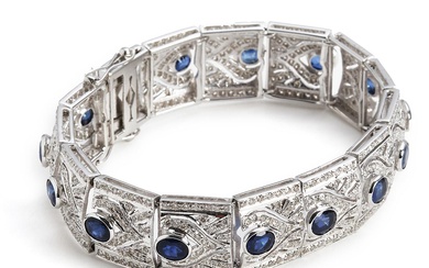 A sapphire and diamond bracelet set with numerous oval-cut sapphires weighing a...