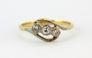 An antique 18ct yellow gold crossover ring set with three diamonds, (N).