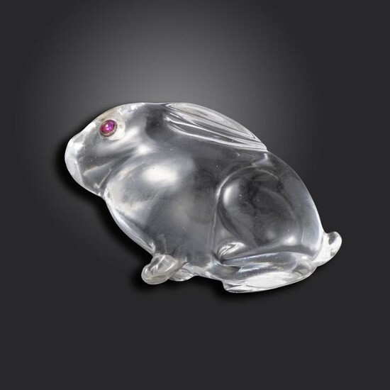 An early 20th century carved rock crystal seated rabbit, in the style of Fabergé, cabochon red stone eyes in rubover mounts, simply carved, broken front right foot, 3cm high