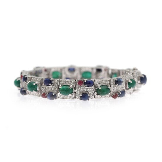 NOT SOLD. An emerald, sapphire and diamond bracelet set with numerous diamonds and numerous emeralds,...