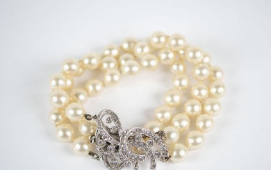 Bracelet à trois rangs de perles, le fermoir en argent 835 millièmes à décor d'entrelacs...