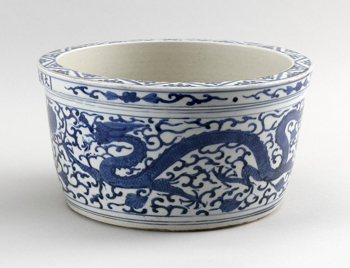 CHINESE BLUE AND WHITE PORCELAIN JARDINIÈRE Decoration of a phoenix and dragon chasing a fiery pearl on a lotus and vine field. Six-...