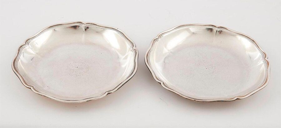 PAIR OF SMALL SILVER LEGS, PARIS 1740-1742 hallmark of the master goldsmith hardly readable J...D. Circular in shape with six contours moulded with net, they had a central coat of arms (blazoned on the back in the 19th century). Pds. 844 g. Diam. 22 cm.