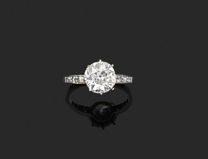 RING in 750 thousandths yellow gold and 850 thousandths platinum, decorated with an antique cushion diamond between two lines of rose-cut diamonds. Finger size: 58.5. Gross weight: 3.1 g. Presumed weight of the diamond: approximately 2.58 ct...