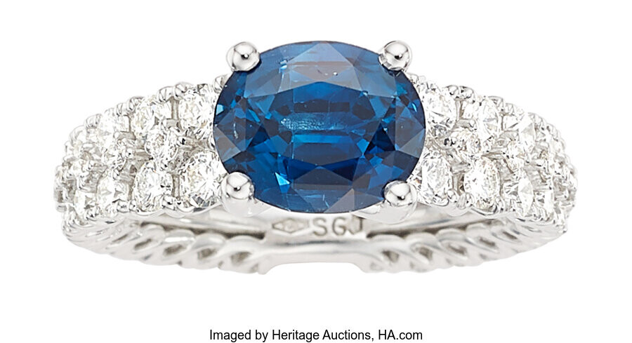 Sapphire, Diamond, White Gold Ring Stones: Oval-shaped sapphire weighing...