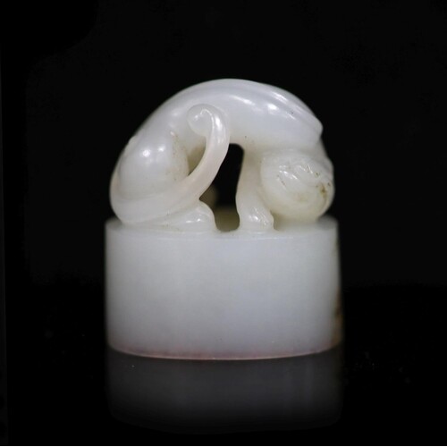 A Chinese white jade oval seal, carved in high relief and op...