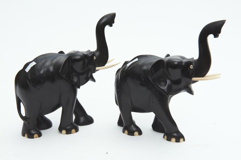 A PAIR OF CEYLONESE EBONY AND BONE CARVED ELEPHANTS WITH RAISED TRUNKS (CRACKS TO WOOD), 21.5 CM HIGH, LEONARD JOEL LOCAL DELIVERY S...