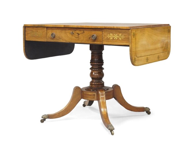 A Regency rosewood and brass-inlaid sofa table, circa 1820, single drawer, raised on a turned stem column, sabre legs to brass paw caps and castors, 73cm high, 141cm wide, 66cm deep