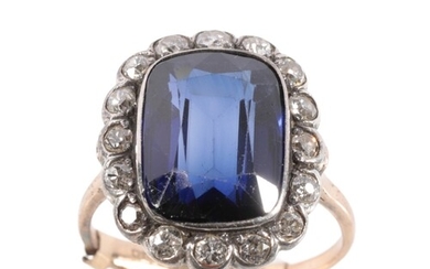 A SYNTHETIC SAPPHIRE AND DIAMOND CLUSTER RING the sapphire 1...