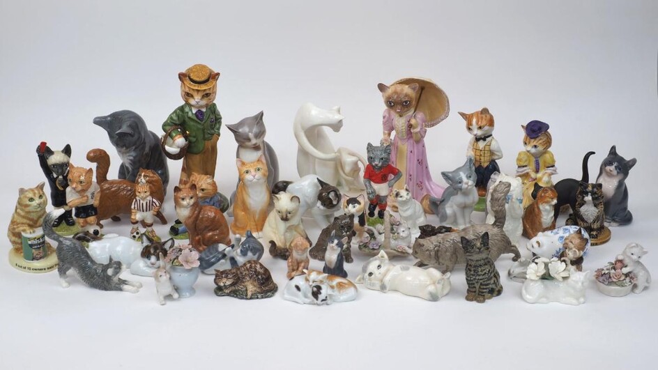 A collection of pottery cats to include; a black basalt salt glazed Wedgewood cat, modelled by Ernest W Light, circa 1913 - 1915 with green glass eyes, 12cm high, examples by Royal Worcester, Wade, Royal Doulton, Beswick, Rosenthal, Meissen...