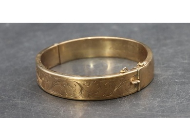A hollow 9ct gold hinged bangle with engraved inner inscript...