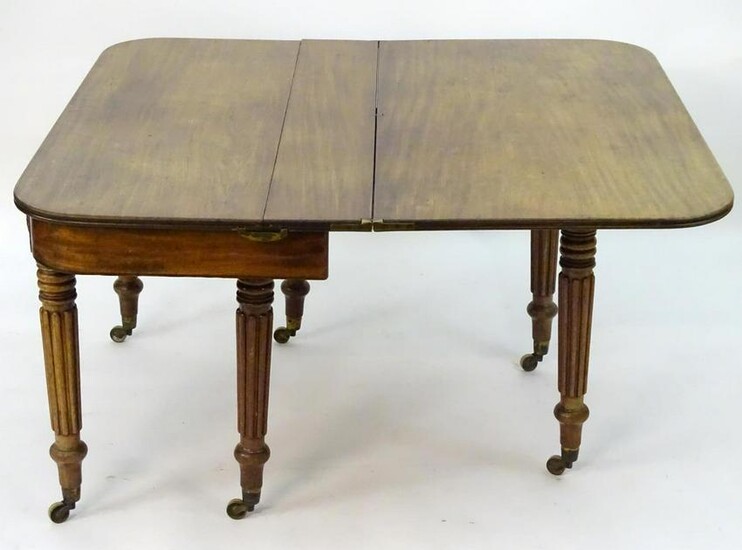 A mid 19thC mahogany extending dining table with a