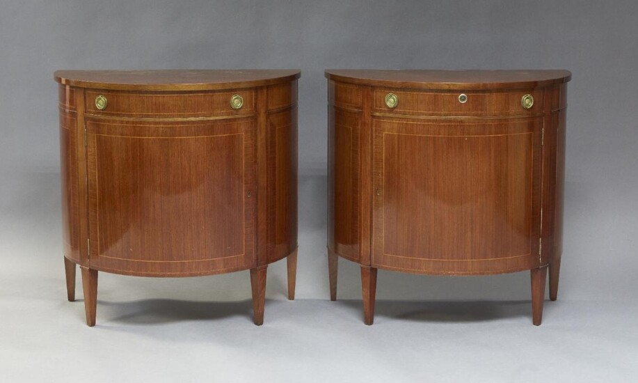 A pair of George III style mahogany demi-lune side cabinets, of recent manufacture, in the manner of George Hepplewhite, each fitted with a single drawer over a single cupboard door below, raised on square tapered supports, inlaid with parquetry...