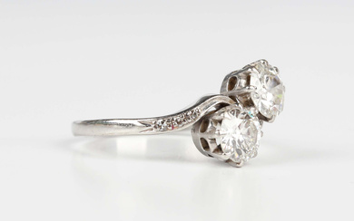 A platinum and diamond ring, claw set with the two principal circular cut diamonds between diamond t
