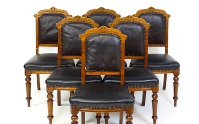 A set of six late 19thC oak Gothic style dining chairs with floral carved top rails, fluted uprights