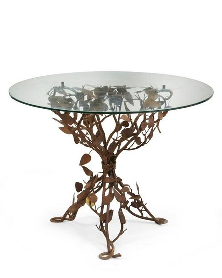 A wrought iron and tole shrub form garden table