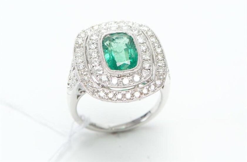 AN ART DECO STYLE EMERALD AND DIAMOND RING IN 18CT WHITE GOLD, CENTRALLY SET WITH A RECTANGULAR CUSHION CUT EMERALD OF 2.23CTS, WITH..
