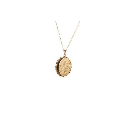AN OVAL PHOTO LOCKET, in 9ct yellow gold with engraved flora...