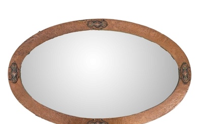 An Arts and Crafts copper frame oval mirror. 83cm x 51cm.