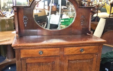 An Edwardian mahogany sideboard with arched cornice above an oval...