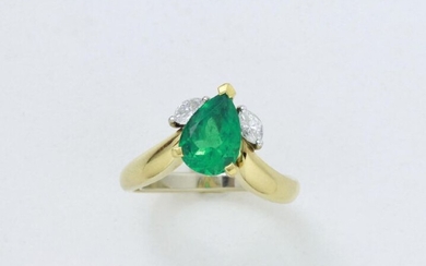 An animated ring in 750 thousandths gold set with a beautifully colored piriform emerald in claw setting with 2 shuttle diamonds.