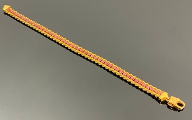 Bracelet en or jaune encadrant une ligne de rubis.