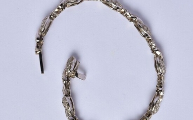 Bracelet semi rigide en or gris 18K (750/oo) à maillons articulés formant des volutes alternées...