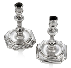 GEORGE I PAIR OF SILVER CANDLESTICKS, Anthony Nelme, London, 1719. Each on stepped square base with incurved corners, the stem rising out of a sunk well with basel and shoulder knop, shaped nozzle. Engraved coat of arms to base. Marked at the bottom:...