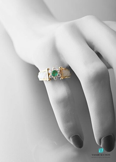 Ring rush yellow gold 750 thousandths, the center with a floral pattern formed by a central emerald surrounded by six brilliants of about 0.02 carat, the shoulders in white mother-of-pearl gadrooned