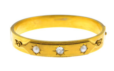 A late Victorian gold diamond and split pearl hinged bangle. View more details