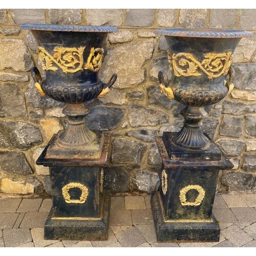 A GOOD QUALITY PAIR OF HEAVY CAST IRON GARDEN URNS ON PLATFO...