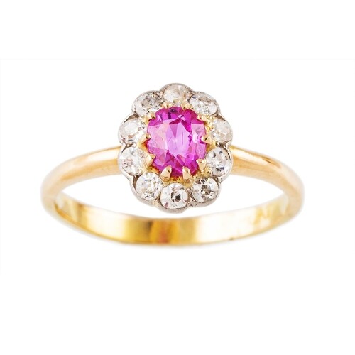A RUBY AND DIAMOND CLUSTER RING, the oval ruby to an old cut...