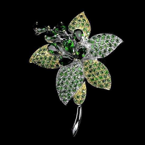 A brooch set with numerous circular-cut peridots and chrome diopsides, mounted in rhodium plated sterling silver. 5.5×3.9 cm.