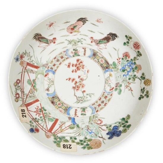A large Chinese famille verte 'chicken' dish, Kangxi period, painted to the central reserve with prunus blossom inside a border decorated with three chickens in a fenced garden, underglaze blue cross-hatch mark inside a double circle to base, 28cm...