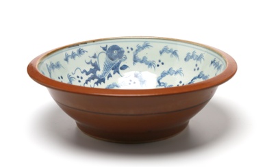 A large blue and white porcelain basin painted to interior with goldfish among aquatic plants, painted to exterior with a brown-colored