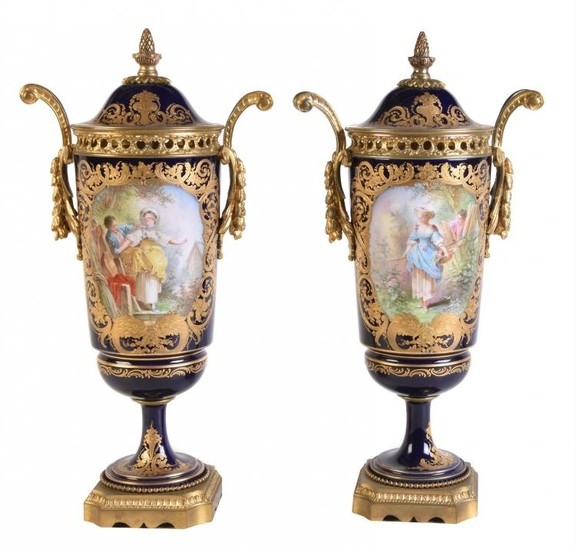 A pair of French porcelain Sèvres-style blue-ground and gilt and gilt-metal-mounted two-handled urns and covers