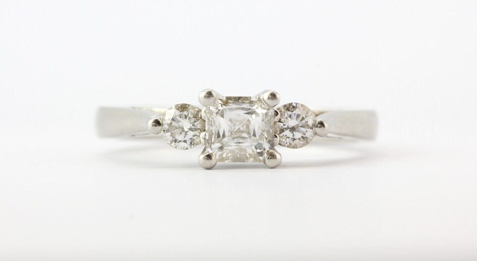 A platinum (stamped 950) ring set with a princess cut diamond and two brilliant cut diamonds, centre stone approx. 0.35ct, (I.5).
