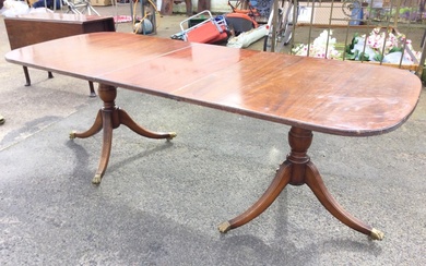 A regency style mahogany twin pedestal dining table with crossbanded...