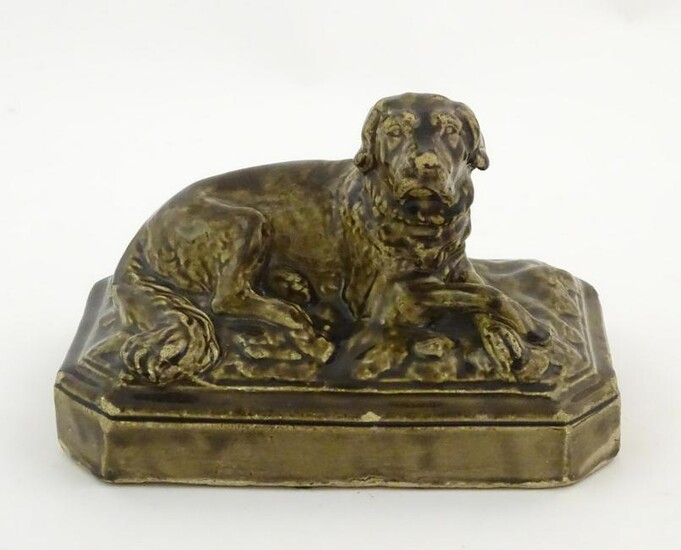 A salt glazed pottery model of a dog on a rectangular